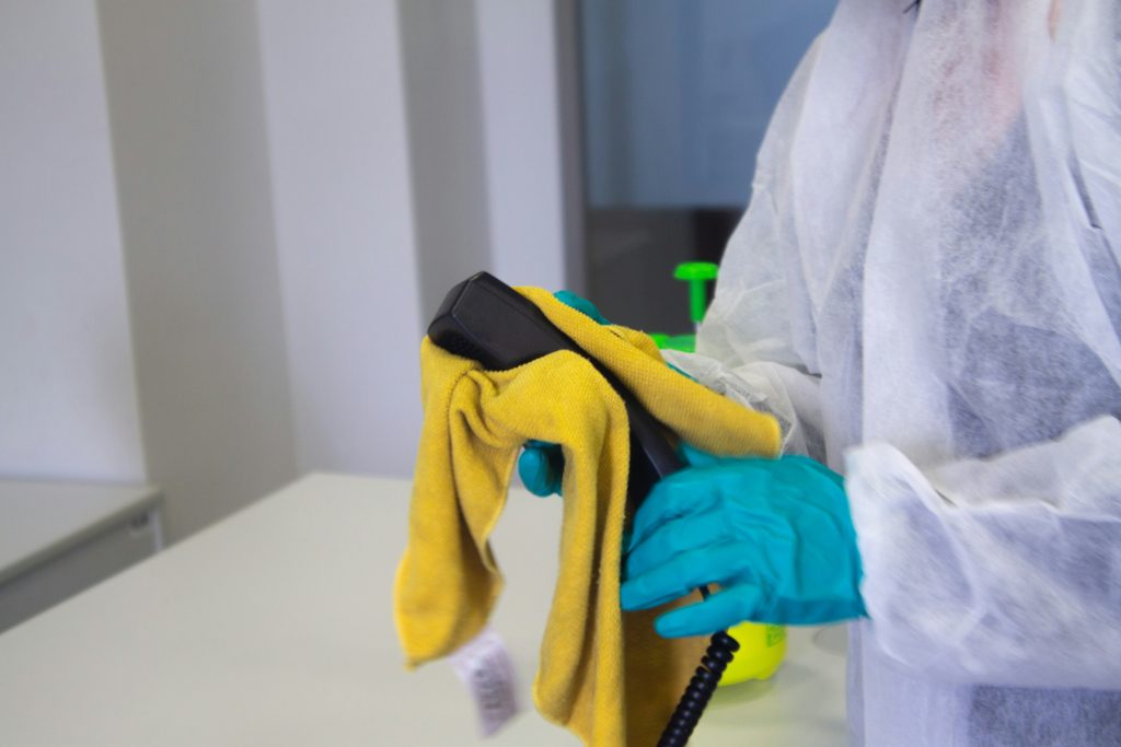 Agent en tenue de protection nettoyant une surface
